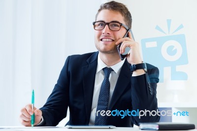 Young Handsome Man Working In His Office With Mobile Phone Stock Photo