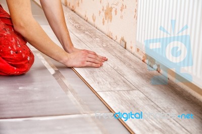 Young Handyman Installing Wooden Floor Stock Photo