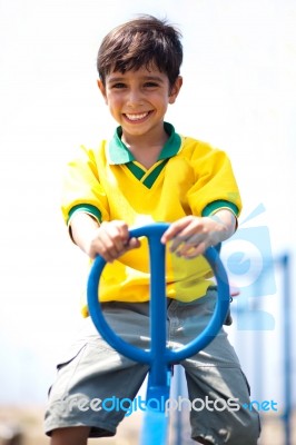 Young Kid Enjoying Swing Ride Stock Photo