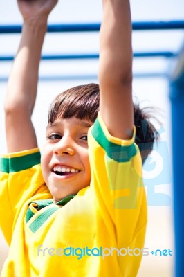 Young Kid Hanging On Jungle Gym Stock Photo