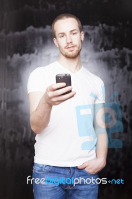 Young Male Holding Smartphone Stock Photo