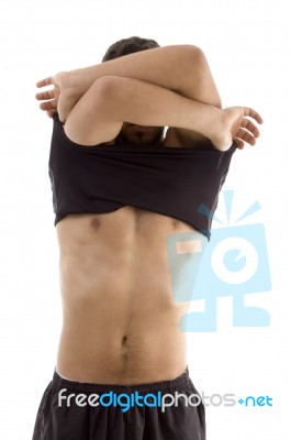 Young Male Removing His Clothes Stock Photo