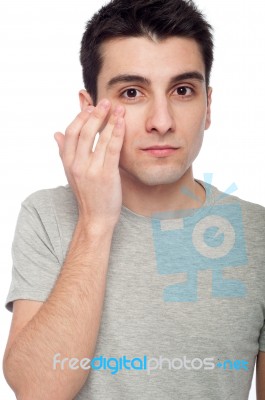 Young Man Applying Eye Cream Stock Photo