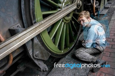 Young Man Cleaning A Steam Train Wheel Stock Photo