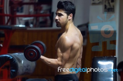 Young Man Doing Heavy Weight Exercise In Gym Stock Photo