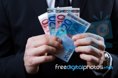 Young Man In Formalwear Holding Money Stock Photo