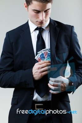 Young Man In Formalwear Putting Money In His Pocket Stock Photo