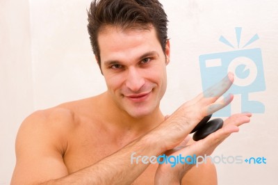 Young Man In Spa Holding Stones Stock Photo