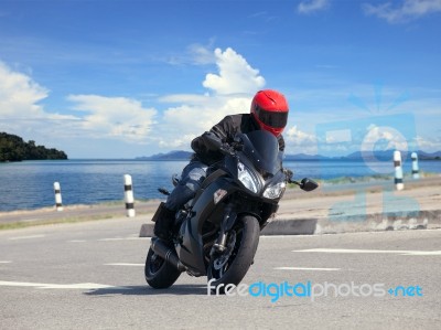 Young Man Riding Big Bike Motorcycle Against Sharp Curve Of Asph… Stock Photo