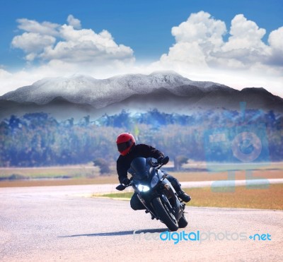 Young Man Riding Motorcycle On Asphalt Road Against Mountain Hig… Stock Photo