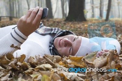 Young Man With Smile And Mobil Phone In Autumun Stock Photo