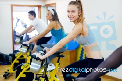 Young People With Fitness Bicycle In The Gym Stock Photo