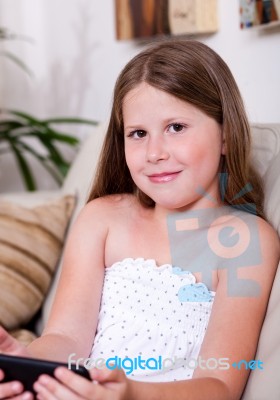 Young Smiling Girl Looking At You In Living Room Stock Photo