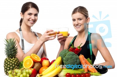 Young Smiling Girls Each Holding Glass Of Juice Stock Photo