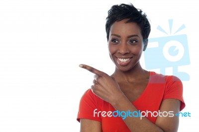 Young Smiling Woman Pointing Away Stock Photo