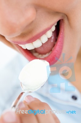 Young Woman Eating Yogurt Stock Photo
