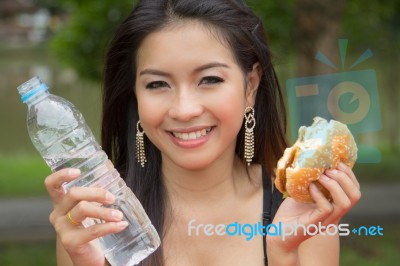 Young Woman Enjoying A Chicken Burger Stock Photo