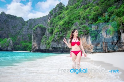 Young Woman In Red Bikini Sitting On The Beach Stock Photo