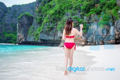 Young Woman In Red Bikini Sitting On The Beach Stock Photo