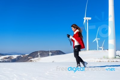 Young Woman Is A Happiness With Camera In Winter Of Sky And Winter Road With Snow And Red Dress Stock Photo