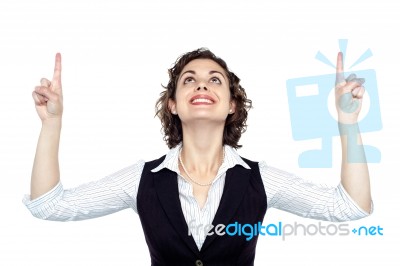 Young Woman Looking And Pointing Upwards Stock Photo