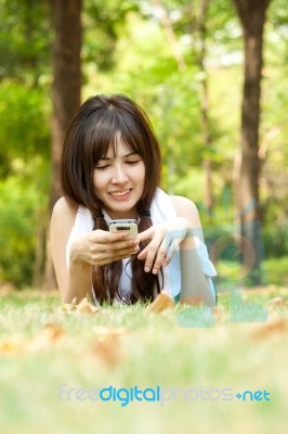 Young Woman Lying With Phone Stock Photo