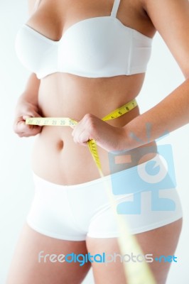 Young Woman Measuring Her Waist By Measure Tape Stock Photo