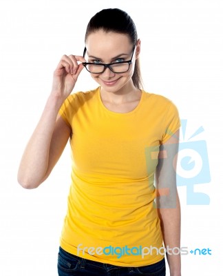 Young Woman Peering Over Glasses Stock Photo