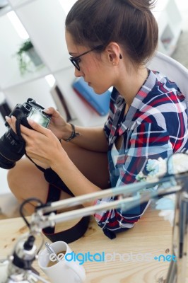 Young Woman Photographer Checking Previews On Camera In The Stud… Stock Photo