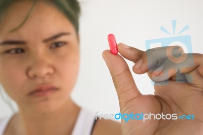 Young Woman Showing A Pill ,woman Healthcare Concept And Ideas Stock Photo