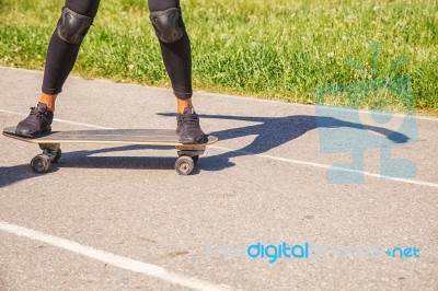 Young Woman Skateboarding In The Park Stock Photo