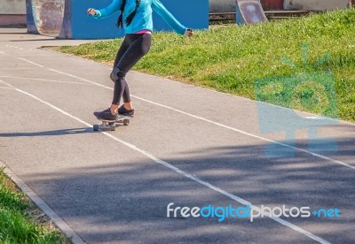 Young Woman Skateboarding In The Park Stock Photo