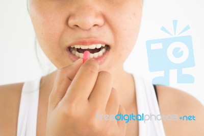 Young Woman Taking A Pill ,woman Healthcare Concept And Ideas Stock Photo