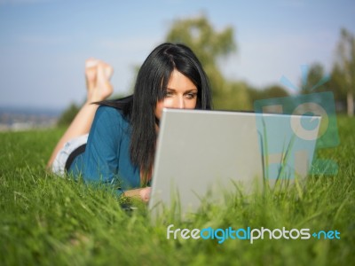 Young Woman Using Laptop In Park Stock Photo