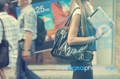Young Woman With Tablet Computer Walking On Street Stock Photo