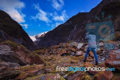 Younger Female Photographer Take A Photograph In Franz Josef Glacier Important Traveling Destination In South Island New Zealand Stock Photo