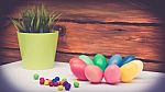 A Few Colorful Easter Eggs As A Flower Shape With Candies Trail And Garden Plants Over Wood Background Left View Close Up Happy Easter Stock Photo