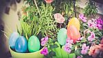A Few Colorful Easter Eggs At The Green Garden With Colorful Flowers Happy Easter Stock Photo