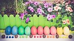 A Few Colorful Easter Eggs At The Green Garden With Colorful Purple  And Pink Flowers And Candies And Chocolate Happy Easter Straight View Stock Photo