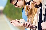 A Group Of Students Having Fun With Smartphones After Class Stock Photo