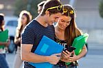 A Group Of Students Having Fun With Smartphones After Class Stock Photo