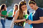 A Group Of Students Having Fun With Smartphones After Class Stock Photo