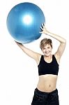 A Healthy Woman Lifting Big Swiss Ball Stock Photo