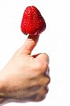 A Strawberry Stuck In Thumb Stock Photo