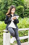 A Young Girl Using Tablet Computer In Park Stock Photo