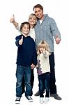 Adorable Family In Winter Clothes Gesturing Thumbs Up Stock Photo