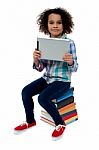 Adorable Kid With Tablet Pc Sitting On Books Stock Photo