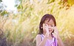Adorable Little Girl Laughing In A Meadow - Happy Girl At Sunset Stock Photo