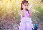 Adorable Little Girl Laughing In A Meadow - Happy Girl At Sunset Stock Photo