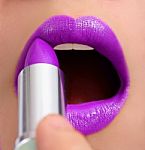 Applying Violet Lipstick Stock Photo